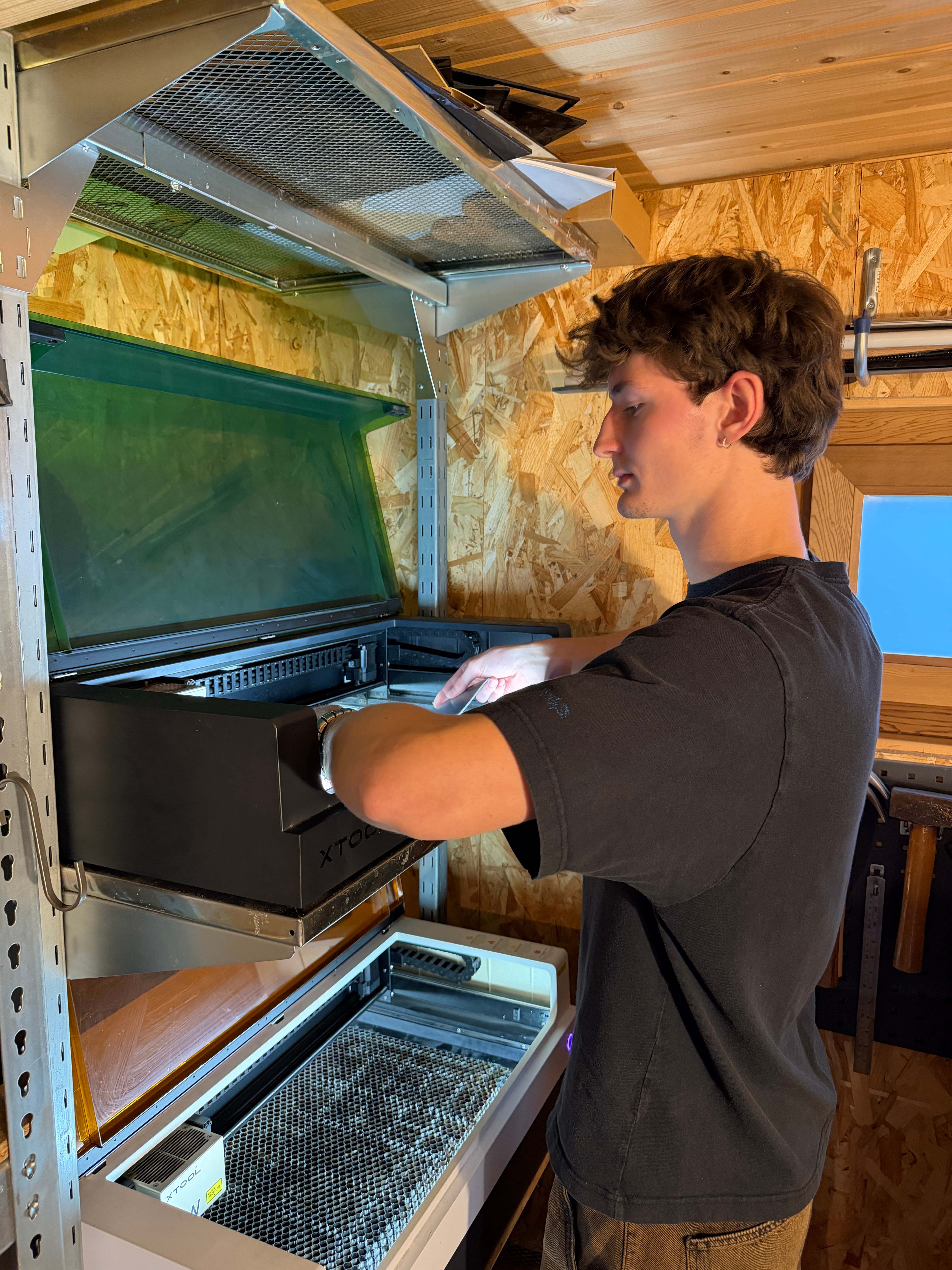 Lukas van Place Maps aan het werk met de lasersnijmachine om een nieuwe batch onderzetters en placemats te maken.